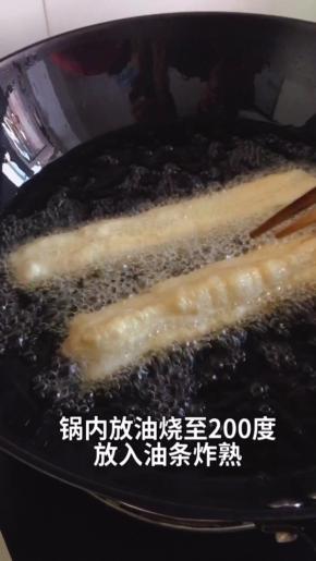 油锅烧热，至200度，放入油条生坯，用筷子不停的拨动油条