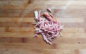 培根一片，先切成段，然后再切成均匀的细丝。
