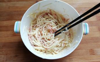 然后我们再把所有这些材料翻拌均匀，边翻拌边加入一点点清水，让玉米淀粉沾满所有食材。