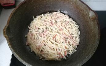 不粘锅先抹一层橄榄油，再把培根土豆糊倒入锅中，用锅铲向四周摊平摊圆，然后盖上锅盖中小火煎蒸。
