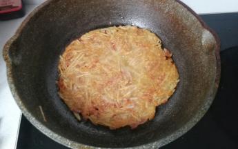 当土豆糊煎制表面发干四周微黄时，再翻面将另一面也煎至金黄即可，煎好后撒点葱花，配点番茄酱超美味哈！
