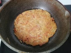 当土豆糊煎制表面发干四周微黄时，再翻面将另一面也煎至金黄即可，煎好后撒点葱花，配点番茄酱超美味哈！
