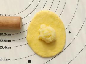 取一份小面团擀开，放入15克椰蓉馅包好，收口收紧朝下。