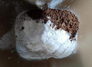 面包机内先放入牛奶、高筋面粉，盐和黑糖粉对角放，中间挖个洞把酵母埋起来。