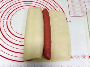 再次向右边卷起盖住，放上最后一个红面团。