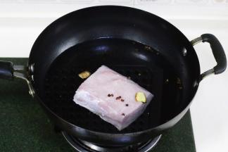 把里脊肉用水冲洗干净，冷水下锅，加入一匙料酒、两片生姜和少许花椒。