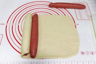 白色面片往右边卷起红色长面团，盖住后再放上第二个红色面团。