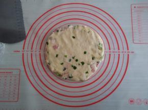 将面团移至案板上，压成圆形，不要压得太薄