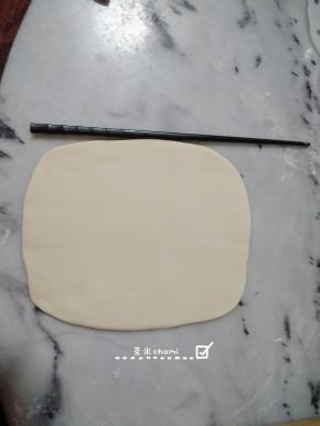 把剩下的白面团，擀成薄片，均匀的抺点水，有助于卷紧粘合。