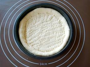 把面团排气，擀成圆饼状，铺到披萨盘中，整理好边缘，用刀叉叉些小孔