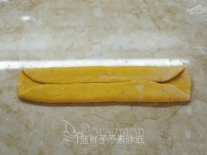 把面团翻面后横过来，上下各自向1/3处折叠，压紧。