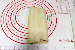 剩下右边的白色面片往左边折过来，捏紧收口。