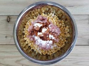 将绞好的肉滑放到玉米大碗上，倒入酱油、糖、盐、玉米淀粉，用筷子朝一个方向搅拌均匀