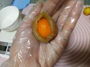 我们北方没有卖生咸鸭蛋的，所以我一般就用真空包装的，不用喷酒烤什么的，个人觉得直接用也没有腥味。用一个莲蓉馅滚圆按扁，包入一颗蛋黄，利用虎口慢慢往上收，然后滚圆
