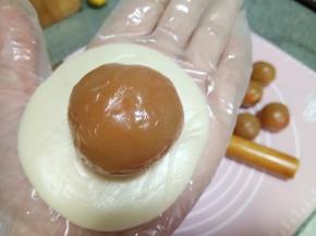 用手掌按压成圆形剂子，放一个馅料上去