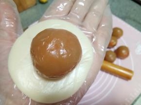 用手掌按压成圆形剂子，放一个馅料上去