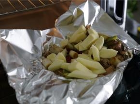 入味好之后，将腌制好的羊排码放在锡纸里，然后再切一个土豆配在一起。