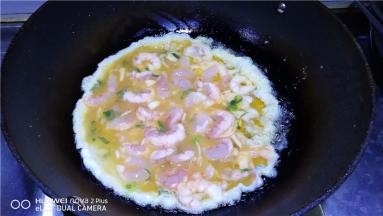 锅中放入适量油，温热时倒入虾仁蛋液。