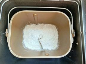 把披萨皮材料除黄油外，以先液体后固体的顺序放入面包机桶，启动揉面程序，揉到扩展加人黄油继续揉