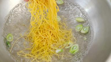 锅中放入清水，葱花煮开后下入面条。