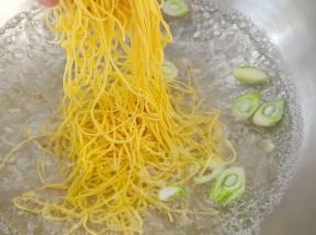 锅中放入清水，葱花煮开后下入面条。