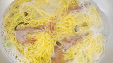 再放入螺旋藻、盐。煮6-7分钟左右放入洗干净的鲜虾。虾煮变色后关火。放入香菜和香油就完成了