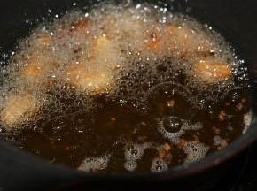 锅内倒入适量食用油，油温6成热下入鸡肉块炸制。