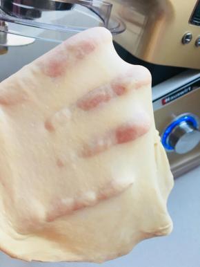 面团出现粗膜后，加入黄油搅打至完全扩展。