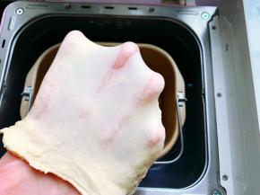 这时扯下一小块面团撑开，面团比较有韧性，呈透明的薄膜状态即可。如果面团揉不到位，会影响面包组织，从而影响口感。