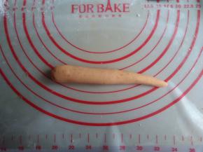 分成每个40-45克的小面团，将面团搓长一点，一边大一边小，搓出胡萝卜的外形