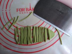 绿色面团擀成薄面片，用法焙客切面刀切出若干条细小的面条