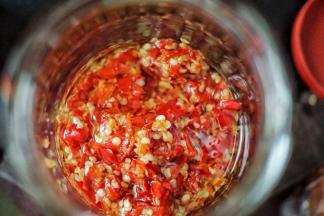 取一干净无油脂水分的玻璃器皿，放入剁椒，然后倒入适量的菜籽油