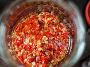 取一干净无油脂水分的玻璃器皿，放入剁椒，然后倒入适量的菜籽油