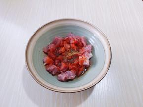 将切好的肉块放入器具中，加入料酒，用手抓拌均匀，再加入生抽，烤肉料。