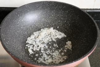热锅后倒入适量玉米油，再倒入洋葱煸炒出香味；