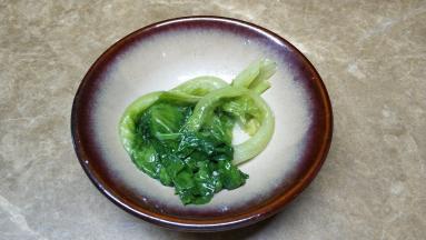 青菜放入碗中，捞出营养美味的龙利鱼云吞放在碗里