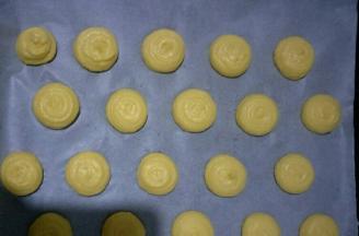 挤在铺一层油纸的烤盘中，每个之间留出一定的距离(可以买那种曲奇&马卡龙烤盘，上面均匀画出了大小和距离)