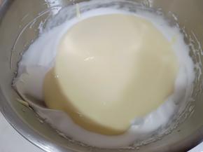 将拌好的蛋黄糊倒入剩余的蛋白霜中翻拌均匀。