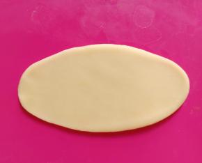 取一个面团，从中间分别往上、下擀成舌状。