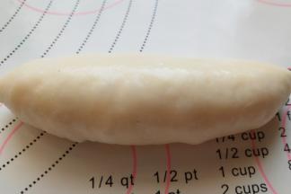 将一侧面团对折，将面团边缘部位黏合在一起，摁压并滚动面团整理下形状，用这个方法将所有面团做完