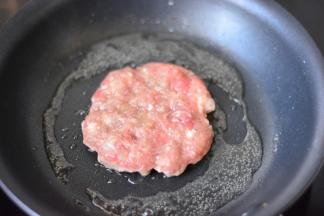 平底锅放少量的食用油，烧热，然后放入肉饼，大火先把两面各煎1分钟，让表面熟透，转最小火，盖上锅盖，焖上3-5分钟，让里面的肉馅熟透