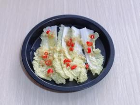 将洗干净的娃娃菜切条，铺在烤盘底下，把腌制虾的酱汁淋在娃娃菜上，再盛一勺辣椒蒜末油浇在上面。