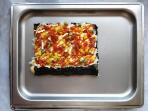 将烤好的寿司披萨取出，表面挤少许过筛后的披萨酱以增加风味。