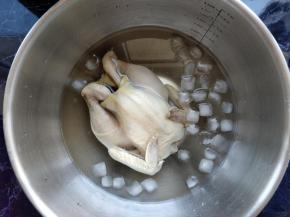 将整只鸡泡入冰水中，冰镇之后口感更好。