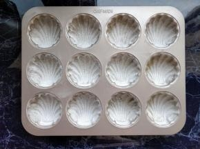 另融化少许黄油（标注的分量外），用毛刷均匀涂在玛德琳模具内，再撒少许低筋粉（分量外），轻拍去除多余的面粉。我用的模具是学厨不粘日式玛德琳模具，每个玛德琳模具的容量稍大，如使用其他模具，材料用料可酌情增减。