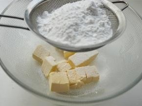 黄油室温软化，能轻易按出一个坑的状态。然后筛入糖粉和盐，先用打蛋头搅拌一下，至糖粉和黄油混合。