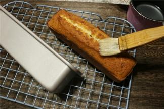 烤蛋糕的时候开始煮糖水。将15克砂糖和清水放进奶锅中，煮至水沸腾之后，立刻关火。烤好的蛋糕拿出来，放在烤网上，用毛刷将糖浆刷到蛋糕的地面和四周，各个面都刷到，会看到糖浆渗进去，尽情的多刷一些。刷好糖浆的磅蛋糕用保鲜袋装起来，冷藏2天后食用，风味更佳。