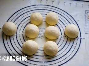 发酵好的面团倒扣在案板上，案板上撒一点面粉防粘，面团排气后分成均等的8份，滚圆，盖保鲜膜醒发20分钟左右。