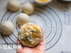 醒发后的面团用手拍扁，翻面后先放入半片左右撕开的芝士片，再放入适量的馅料。