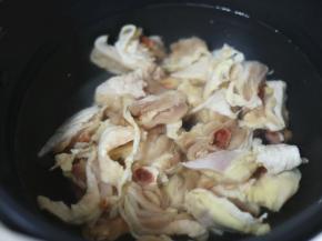 将适量清水倒入九阳炒菜机中，倒入鸡腿肉，加入料酒和一点姜片。